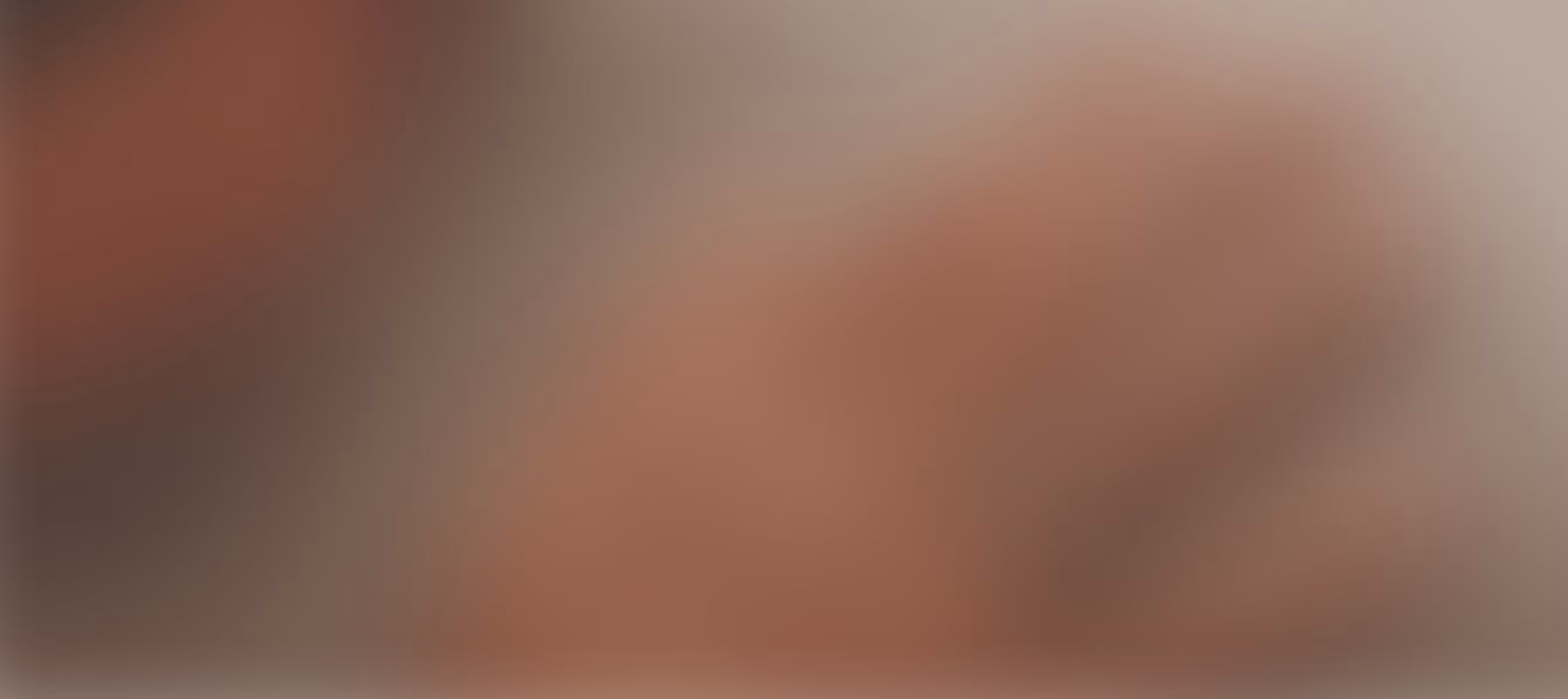 Blurred background image of a hand wearing an Oura ring on the ring finger