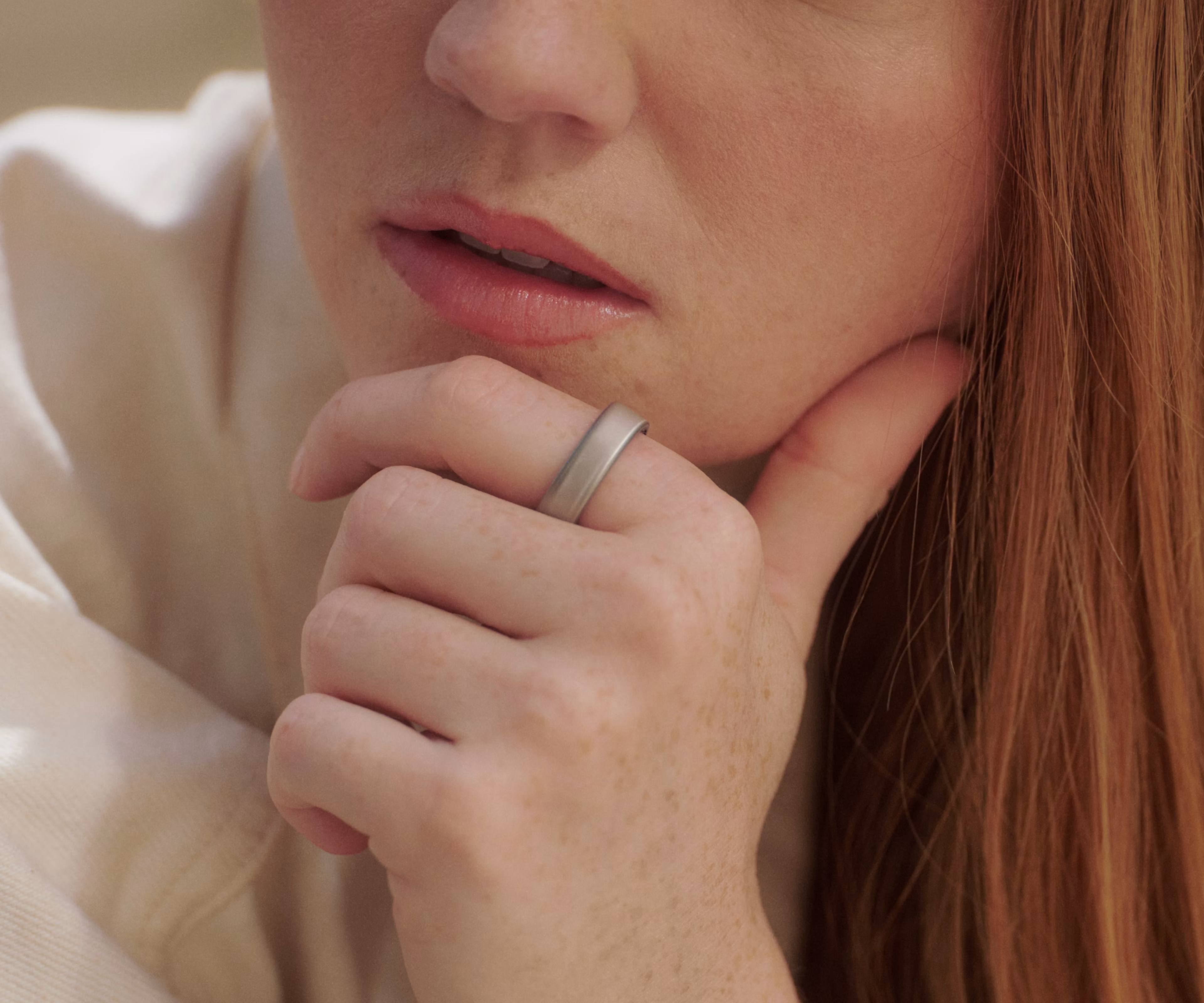 Close up of a person in a thoughtful pose while wearing a Brushed Silver Oura Ring 5.