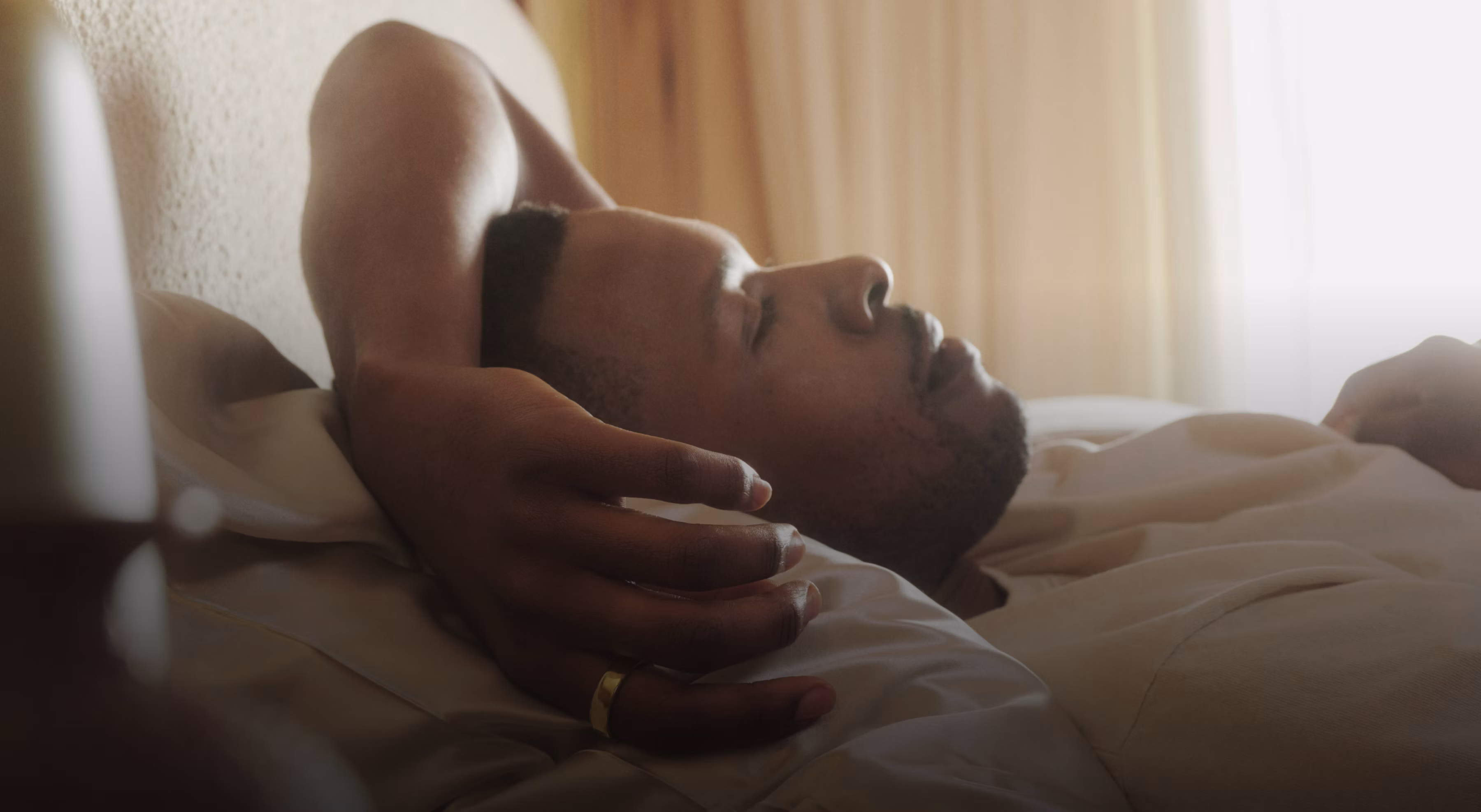 Man lying in bed wearing an Oura Ring 5