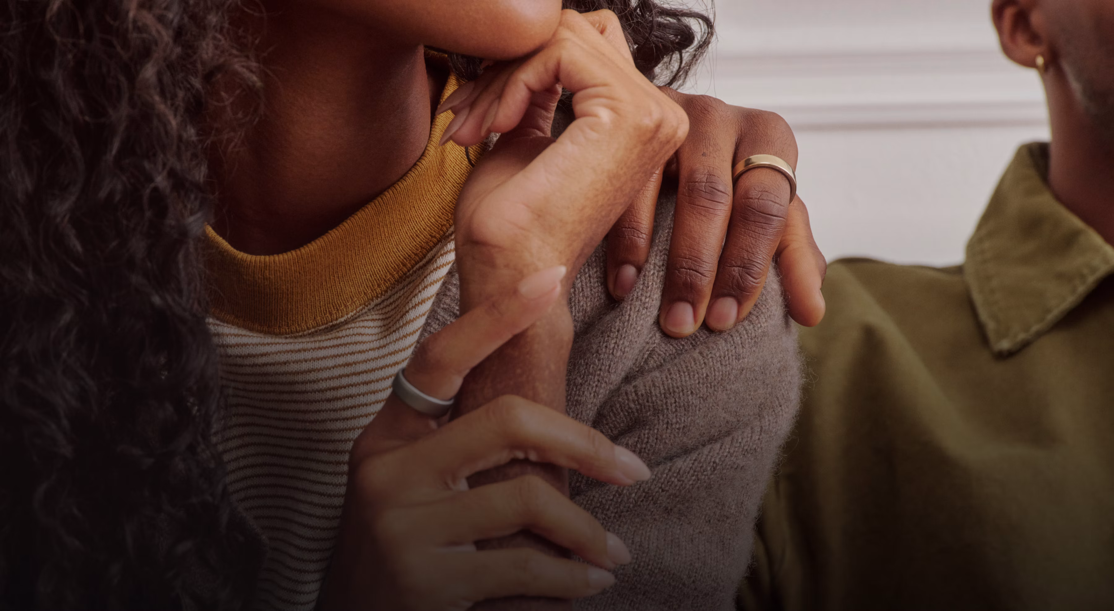 Person putting their hand on the shoulder of another person both wearing an Oura Ring 5