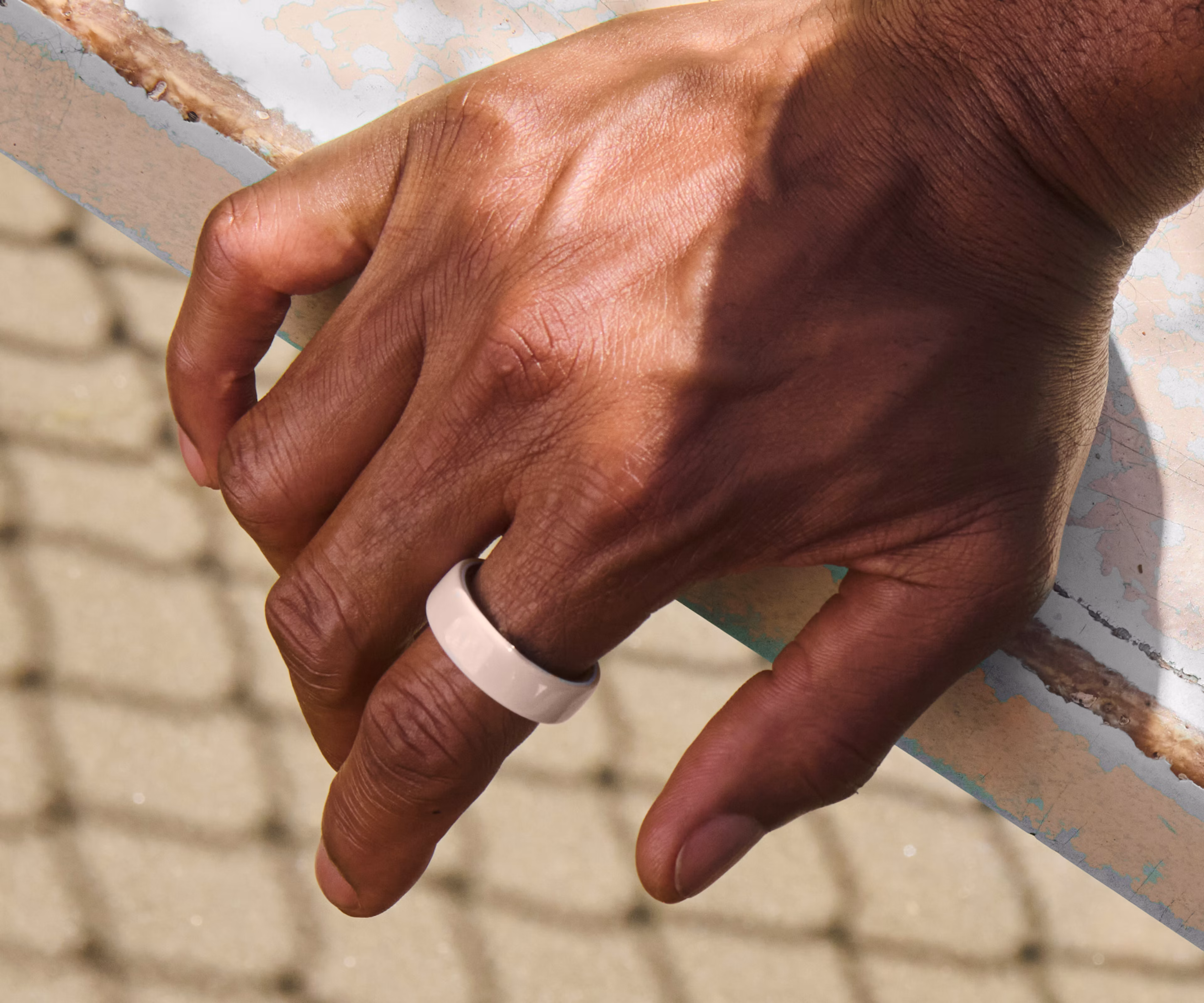 Close up of a person's hand with a Cloud Oura Ring 4 Ceramic on their finger