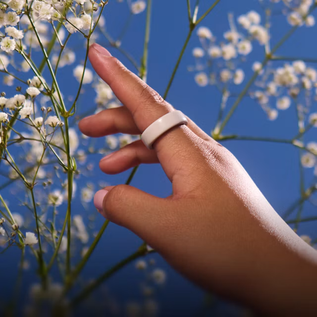 Close up of a person's hand with a Cloud Oura Ring 4 Ceramic on their finger